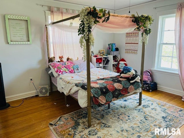 bedroom featuring baseboards and wood finished floors