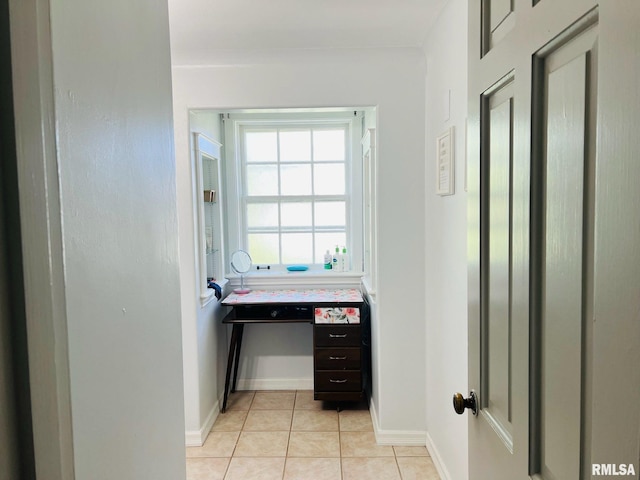 hall with baseboards and light tile patterned floors
