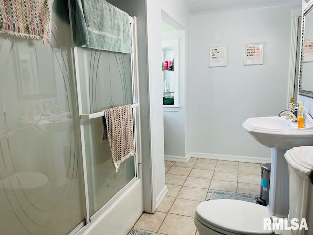 bathroom with tile patterned flooring, baseboards, and toilet