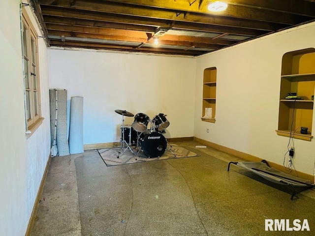 basement with baseboards and built in features