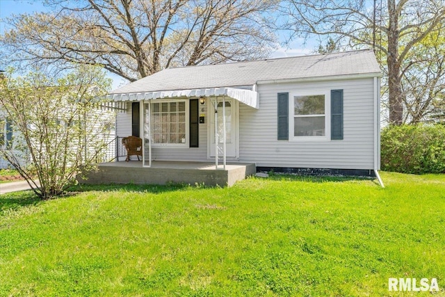 bungalow featuring a front lawn, covered porch, and roof with shingles