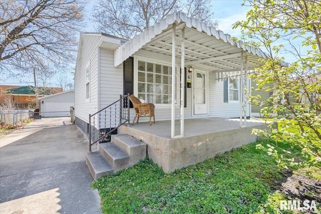 back of house with an outdoor structure, fence, and a garage