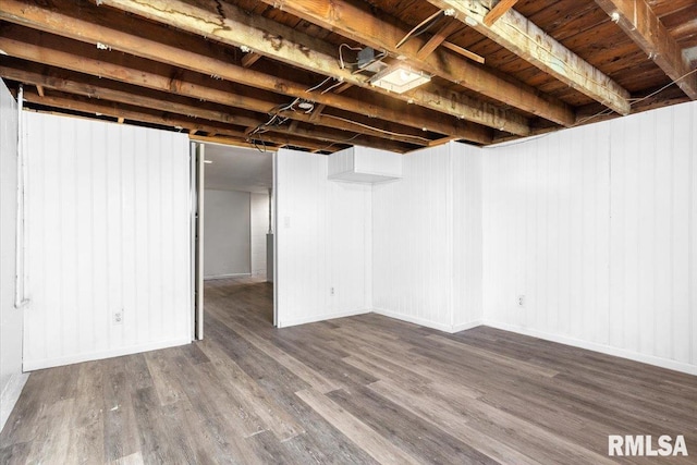 finished below grade area with baseboards and wood finished floors