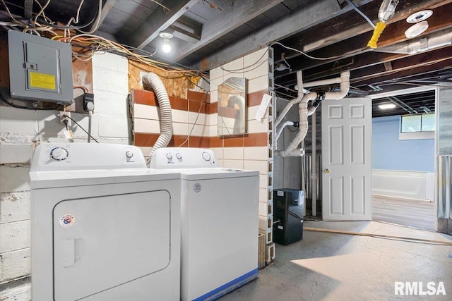 clothes washing area with washing machine and dryer, electric panel, and laundry area