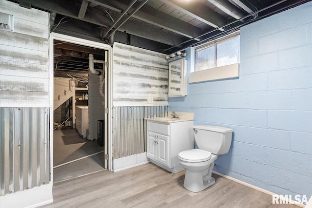 bathroom with wood finished floors, toilet, and vanity