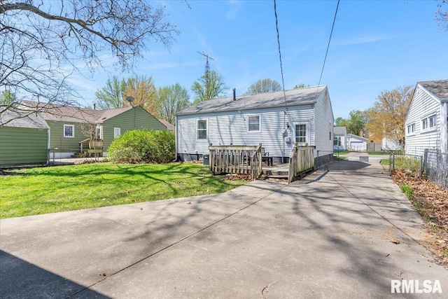 back of house with a wooden deck, a lawn, fence, and driveway