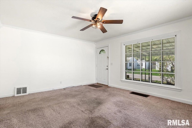 empty room with visible vents, carpet, ceiling fan, and crown molding