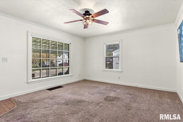 empty room featuring a ceiling fan, ornamental molding, visible vents, and carpet