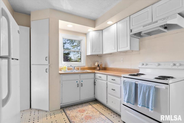 kitchen featuring white cabinets, a sink, recessed lighting, white appliances, and under cabinet range hood