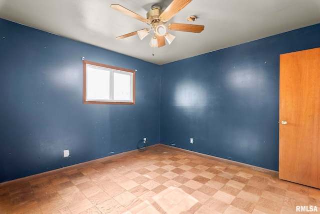 spare room with baseboards and ceiling fan