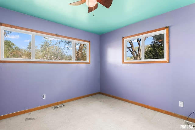 empty room with baseboards, a healthy amount of sunlight, and carpet