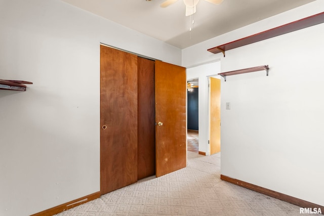 unfurnished bedroom with a closet, a ceiling fan, and baseboards