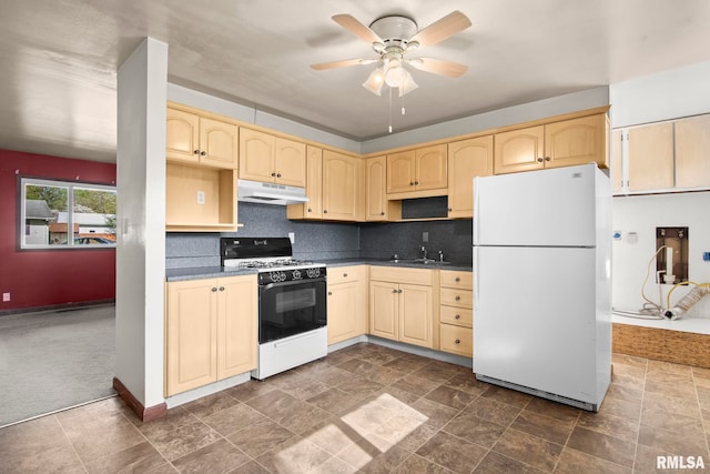 kitchen with a ceiling fan, a sink, under cabinet range hood, gas stove, and freestanding refrigerator