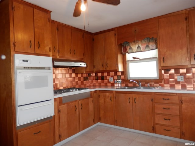515 Franklin Ave, Galesburg, IL 61401 - kitchen featuring white oven, a warming drawer, under cabinet range hood, a sink, and a ceiling fan