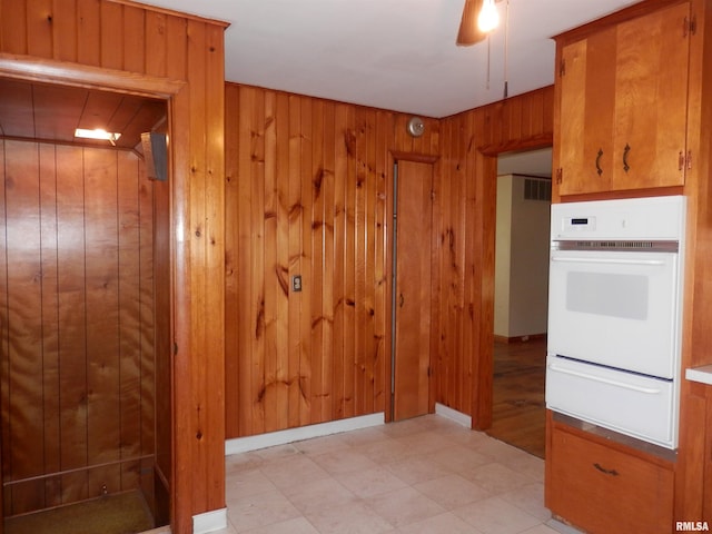 515 Franklin Ave, Galesburg, IL 61401 - kitchen featuring a warming drawer, oven, wood walls, and brown cabinets