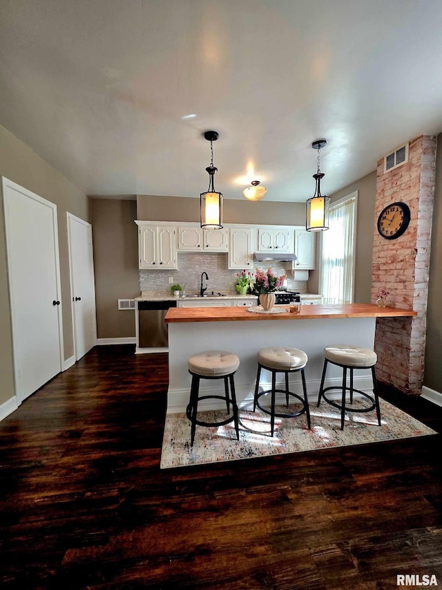 419 S 16th St, Quincy, IL 62301 - kitchen featuring butcher block counters, white cabinets, under cabinet range hood, and a sink