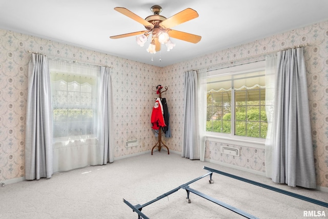 interior space with carpet flooring, wallpapered walls, baseboards, and ceiling fan
