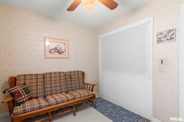 living area with a ceiling fan, carpet, and wallpapered walls
