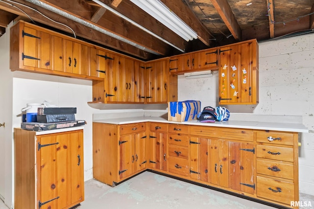 kitchen with light countertops, concrete flooring, and brown cabinets
