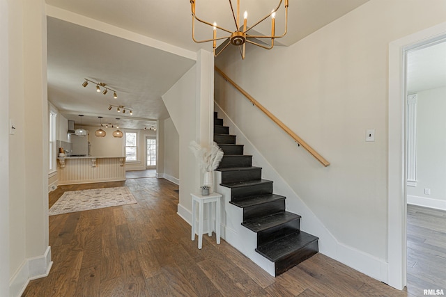 203 Oglesby Ave, Lincoln, IL 62656 - staircase with wood finished floors, rail lighting, baseboards, and an inviting chandelier