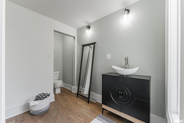 203 Oglesby Ave, Lincoln, IL 62656 - bathroom with wood finished floors, toilet, baseboards, and a sink