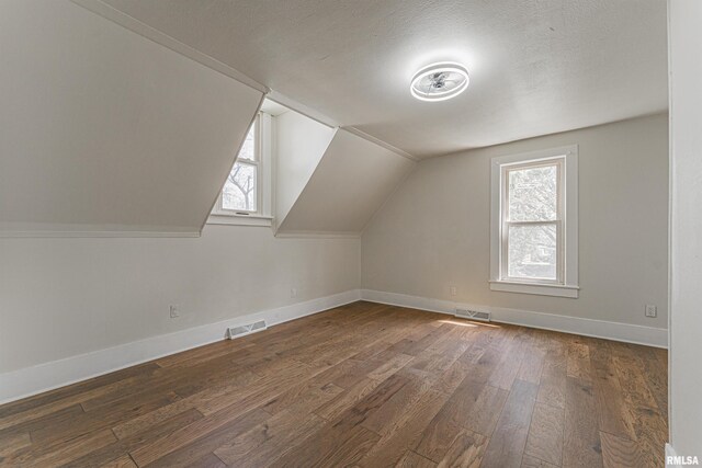 203 Oglesby Ave, Lincoln, IL 62656 - bonus room with wood-type flooring, vaulted ceiling, visible vents, and baseboards
