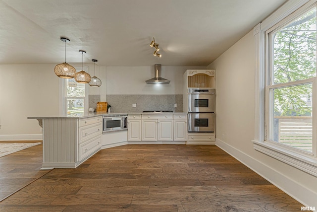 203 Oglesby Ave, Lincoln, IL 62656 - kitchen with stainless steel appliances, wall chimney exhaust hood, a wealth of natural light, decorative backsplash, and a peninsula