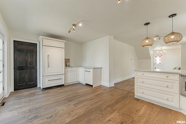 203 Oglesby Ave, Lincoln, IL 62656 - kitchen featuring hanging light fixtures, wood finished floors, a chandelier, light countertops, and baseboards