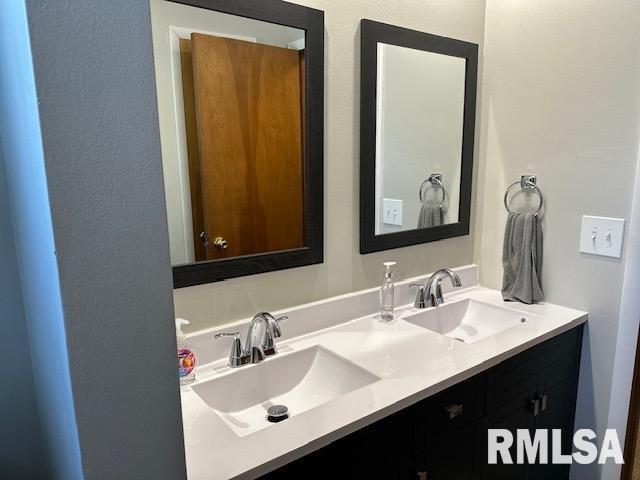 bathroom featuring a sink and double vanity