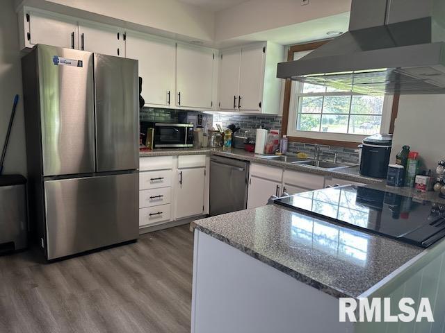 kitchen featuring under cabinet range hood, white cabinets, appliances with stainless steel finishes, and a sink