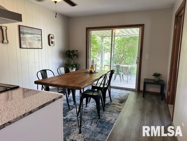 dining area with ceiling fan and dark wood-type flooring
