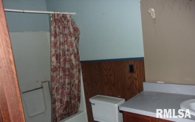 212 Main St, Franklin, IL 62638 - bathroom featuring wood walls, a wainscoted wall, vanity, toilet, and shower / tub combo with curtain