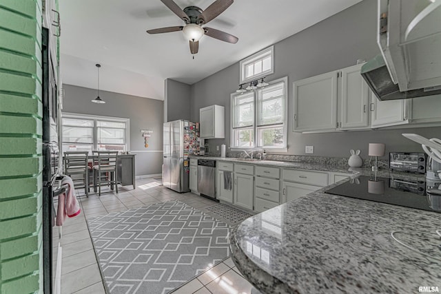 kitchen with a healthy amount of sunlight, light tile patterned floors, stainless steel appliances, ceiling fan, and white cabinetry