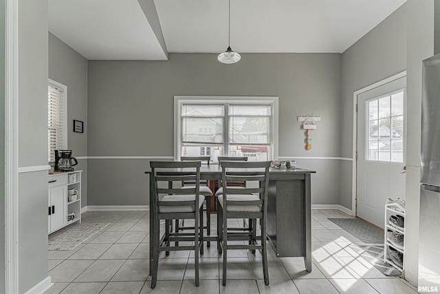 dining space featuring light tile patterned flooring and baseboards