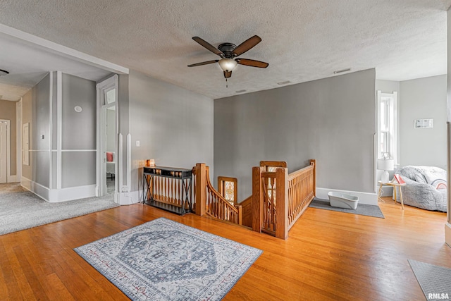 interior space featuring a textured ceiling, wood finished floors, and baseboards