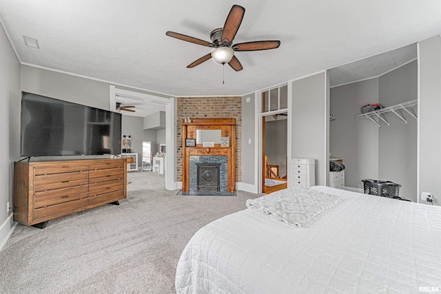 bedroom featuring ceiling fan, baseboards, a fireplace, carpet, and two closets