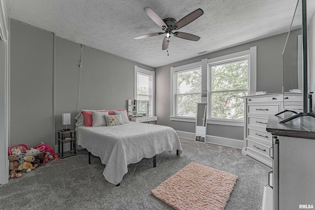 carpeted bedroom featuring a textured ceiling, visible vents, ceiling fan, and baseboards