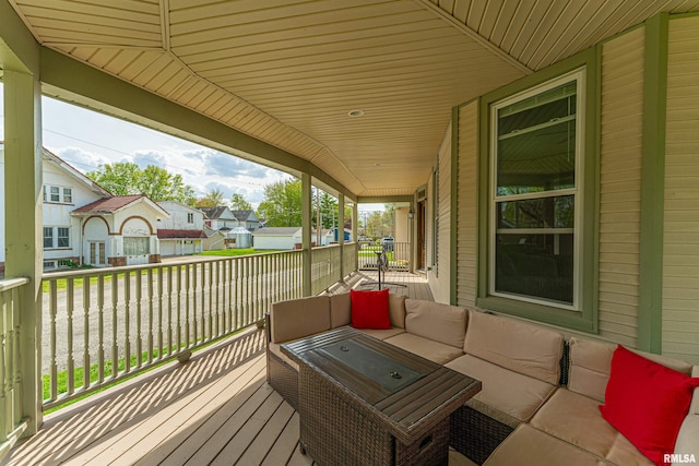 wooden terrace featuring an outdoor living space, a porch, and a residential view