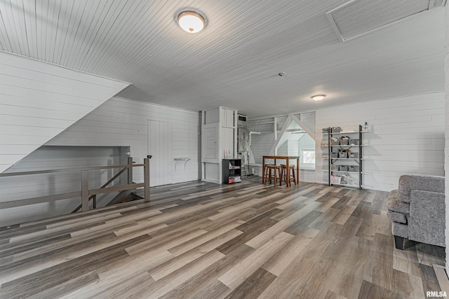 bonus room featuring wooden walls, wood finished floors, and visible vents