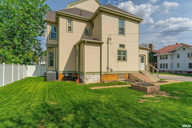 back of house with fence, cooling unit, and a yard
