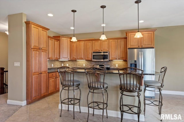 kitchen with tasteful backsplash, stainless steel appliances, dark countertops, and a kitchen bar