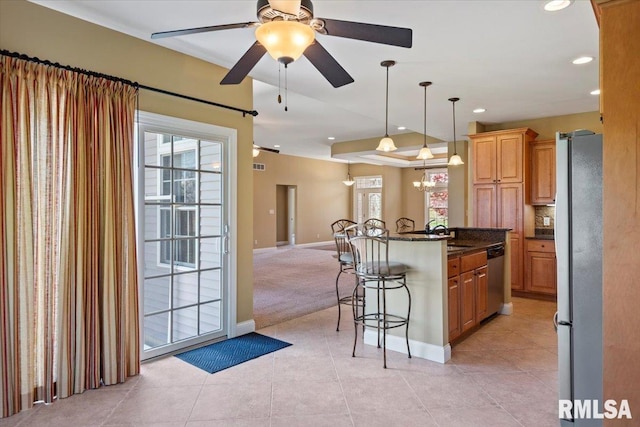 kitchen with recessed lighting, a kitchen breakfast bar, a ceiling fan, appliances with stainless steel finishes, and open floor plan