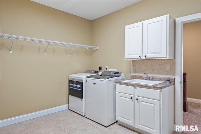 laundry area with independent washer and dryer, baseboards, cabinet space, and a sink