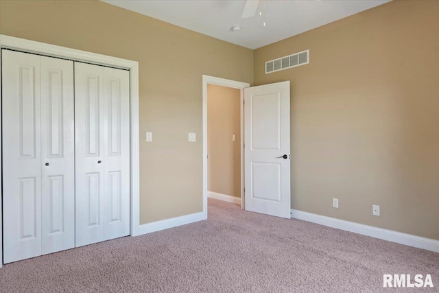 unfurnished bedroom with carpet flooring, a closet, visible vents, and baseboards
