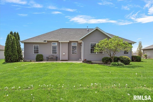view of front of property featuring a shingled roof, a front yard, and a patio area