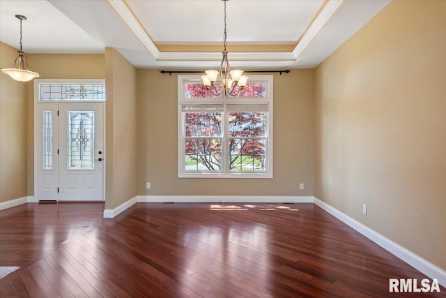 foyer entrance featuring a chandelier, hardwood / wood-style flooring, a healthy amount of sunlight, and a tray ceiling