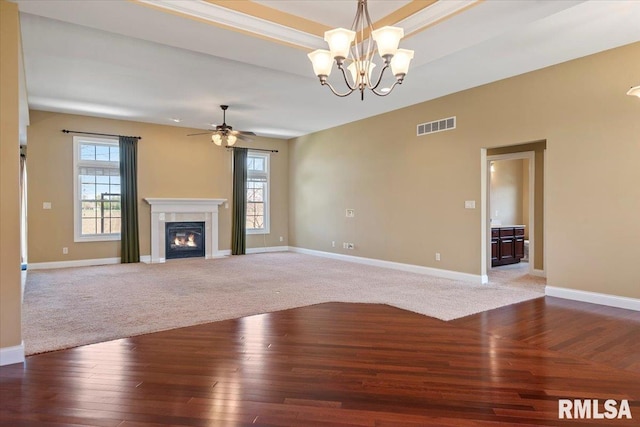 unfurnished living room featuring baseboards, visible vents, wood finished floors, and a healthy amount of sunlight