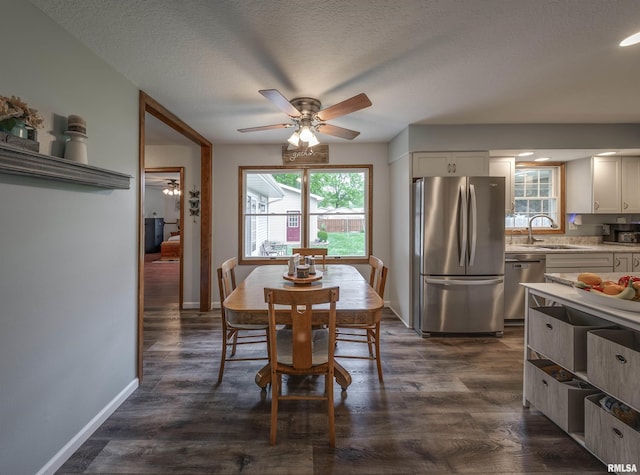dining area featuring dark wood-style flooring, baseboards, and a ceiling fan