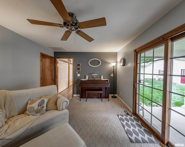 living area with ceiling fan, carpet floors, baseboards, and visible vents