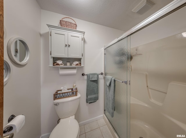 full bath featuring toilet, visible vents, baseboards, tile patterned flooring, and a shower stall
